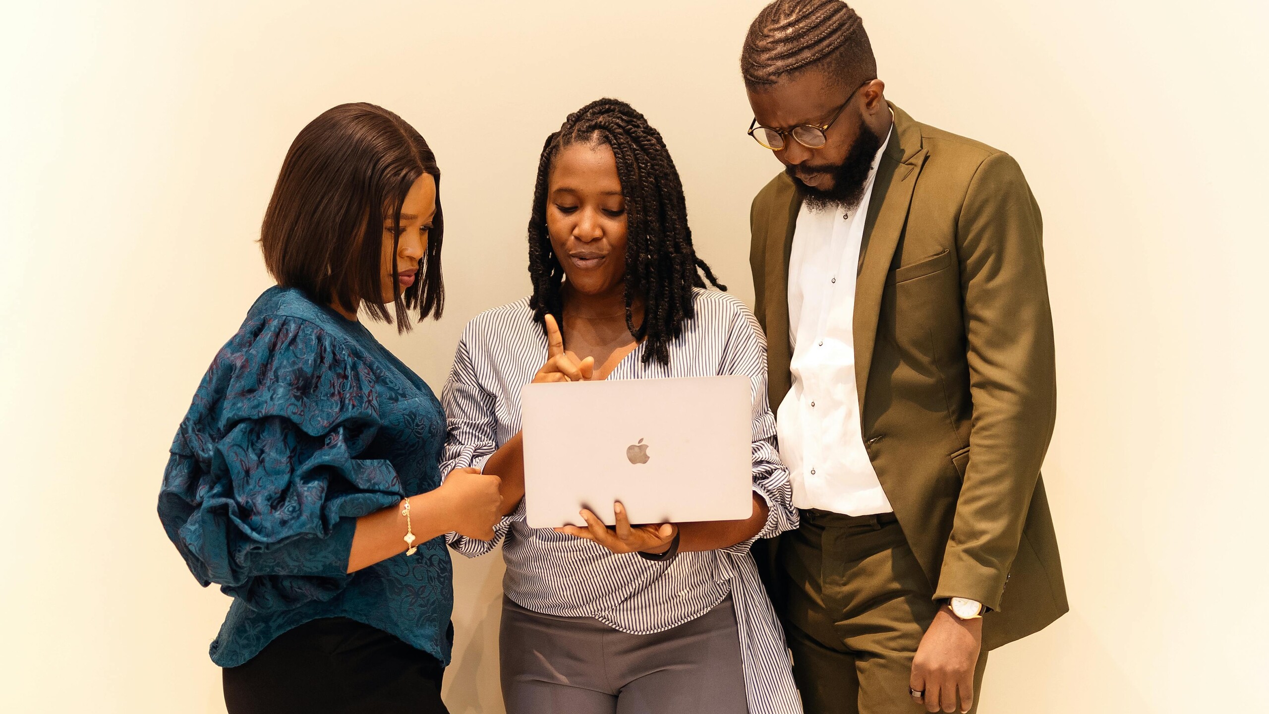 Diverse young professionals collaborating with laptops in a modern office